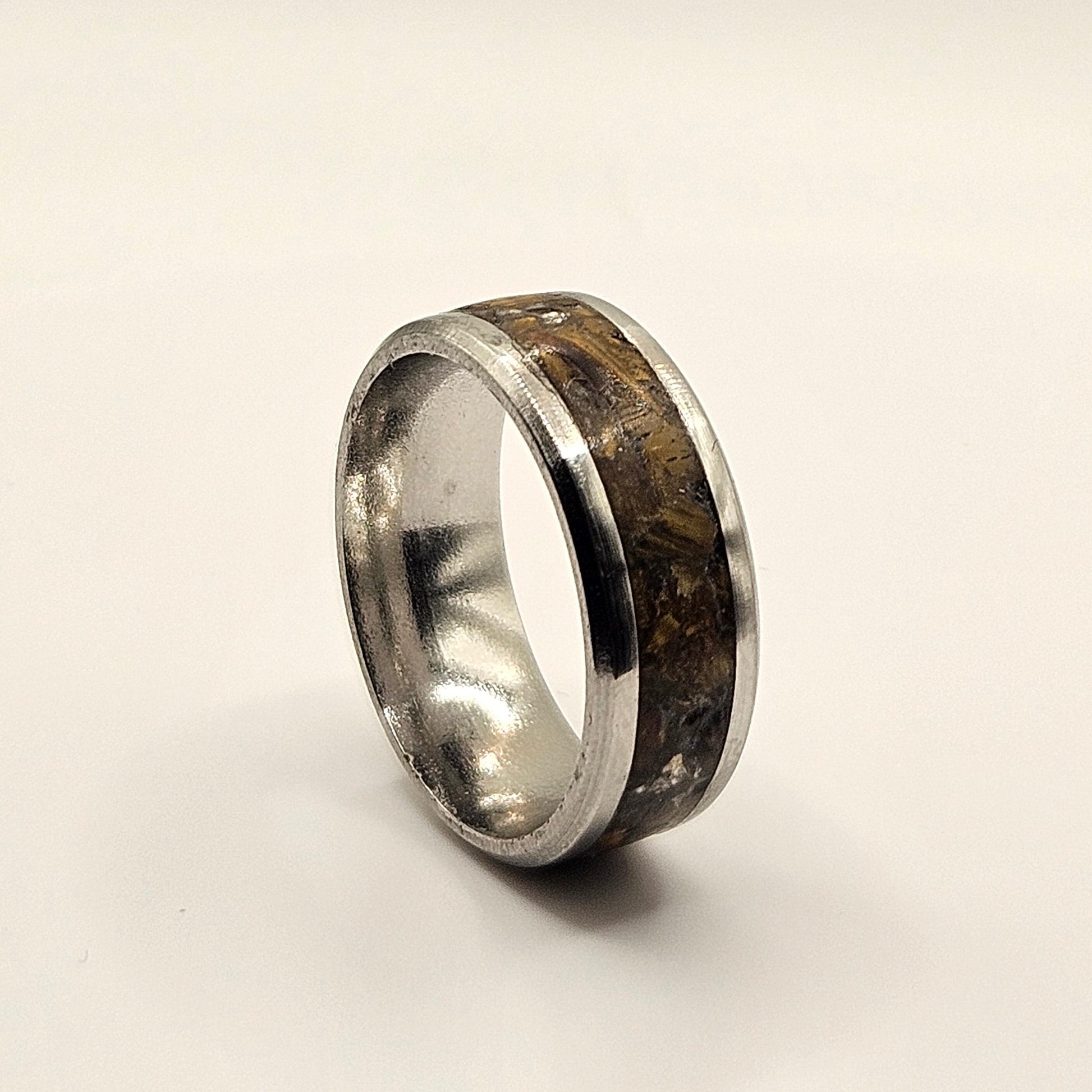 Silver ring with a textured band on a light gray background