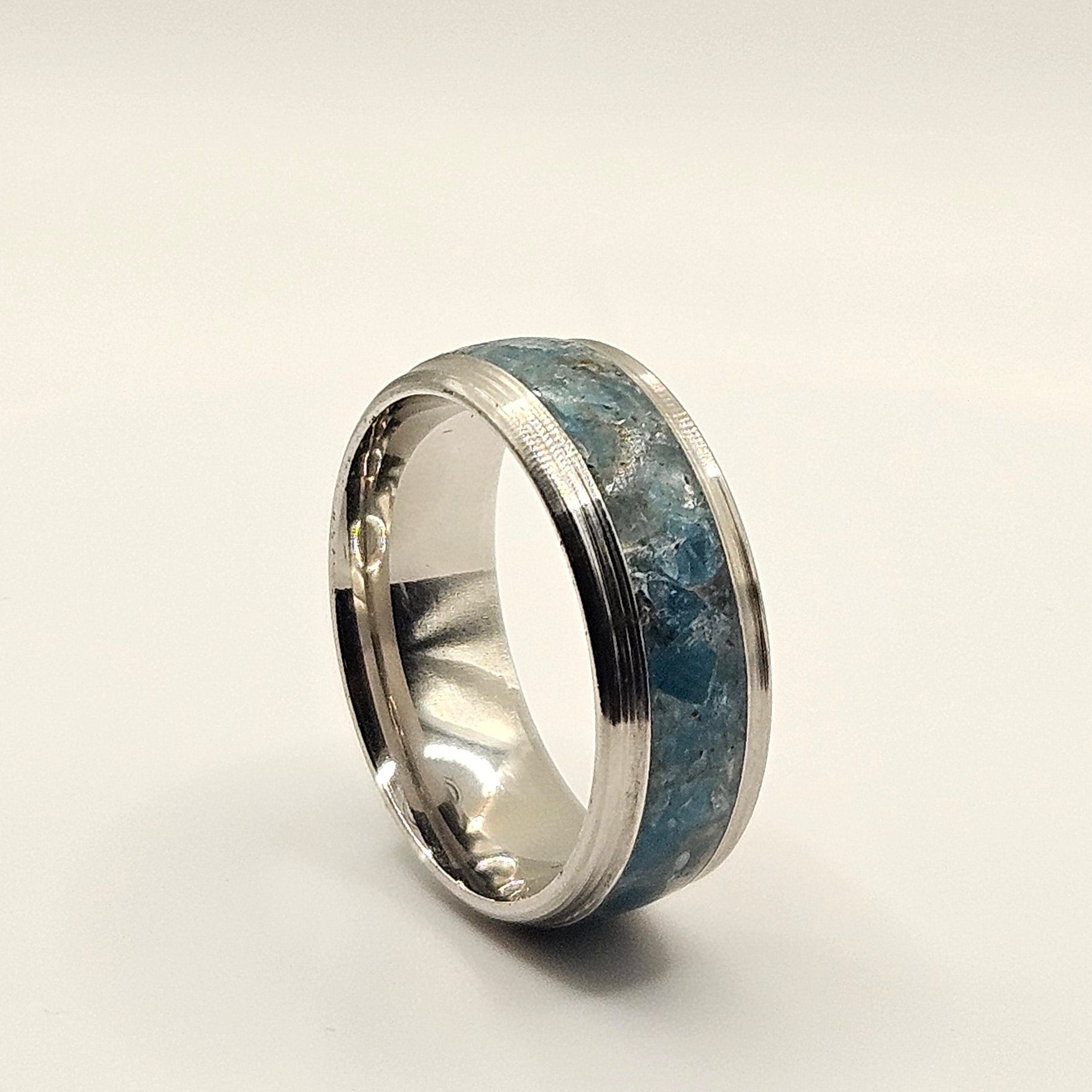 Silver ring with blue pattern on a white background
