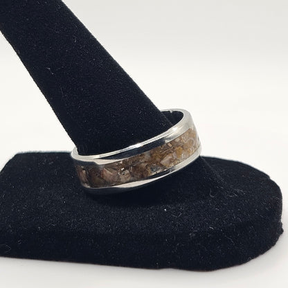 Silver ring on a black stand against a white background