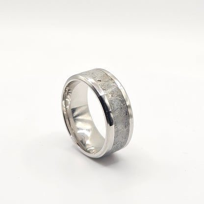Silver ring with a textured band on a white background