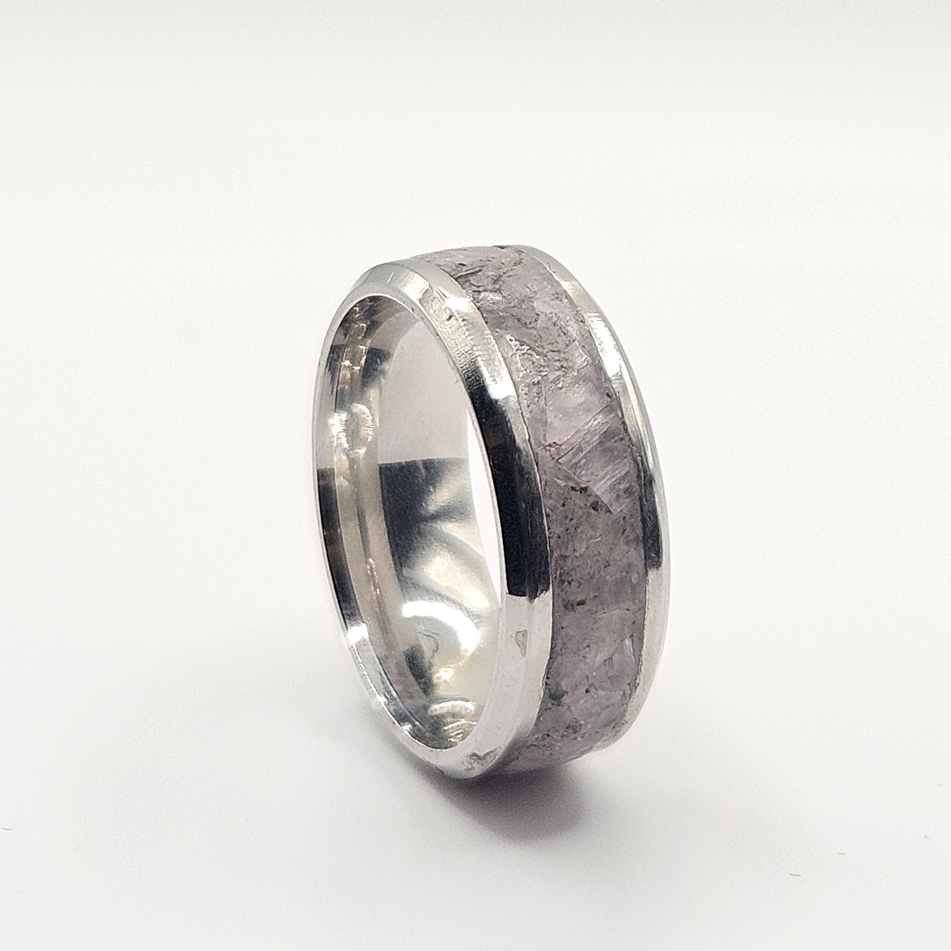 Silver ring with a textured surface on a white background