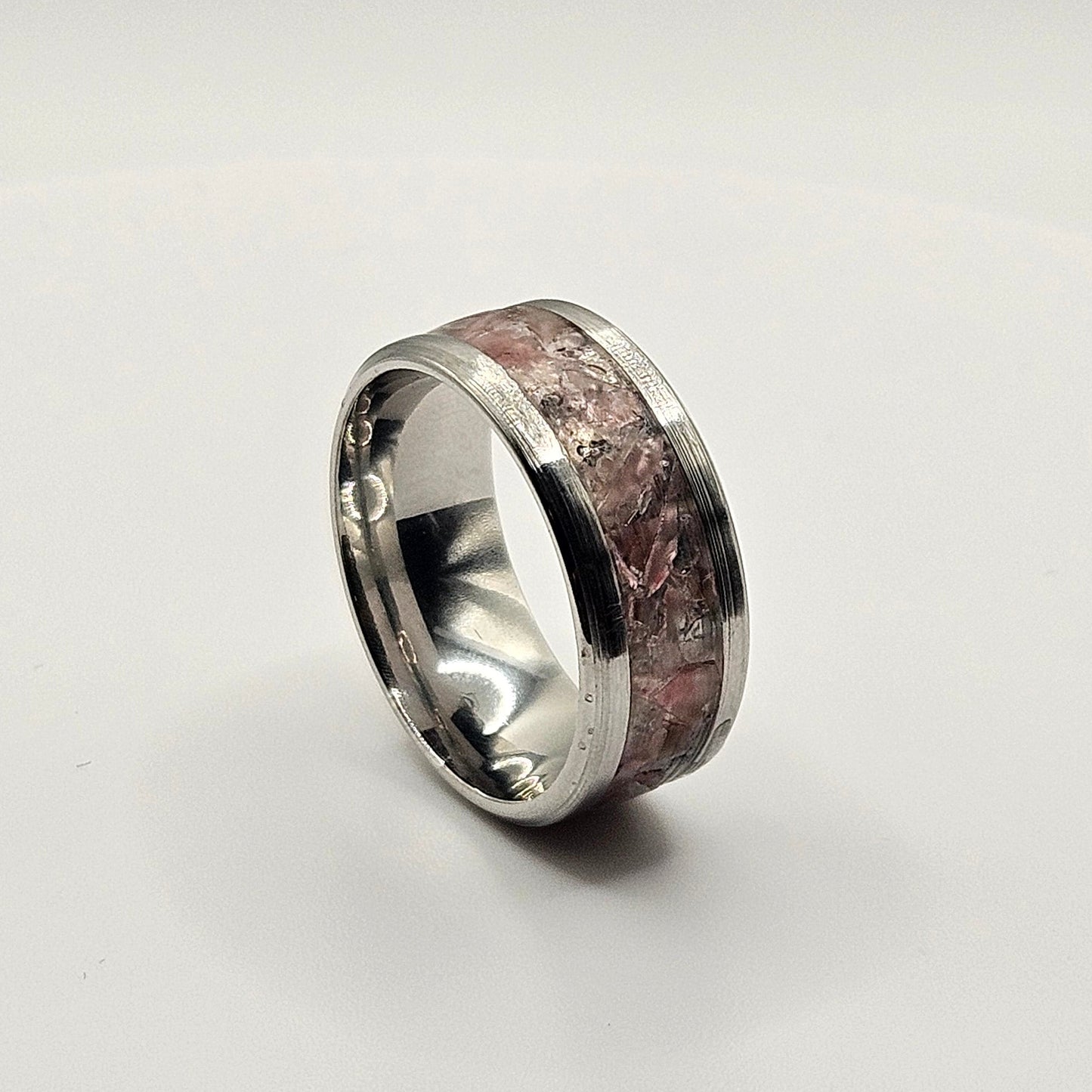 Silver ring with a textured band on a white background