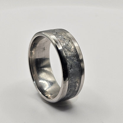 Silver ring with textured band on a white background
