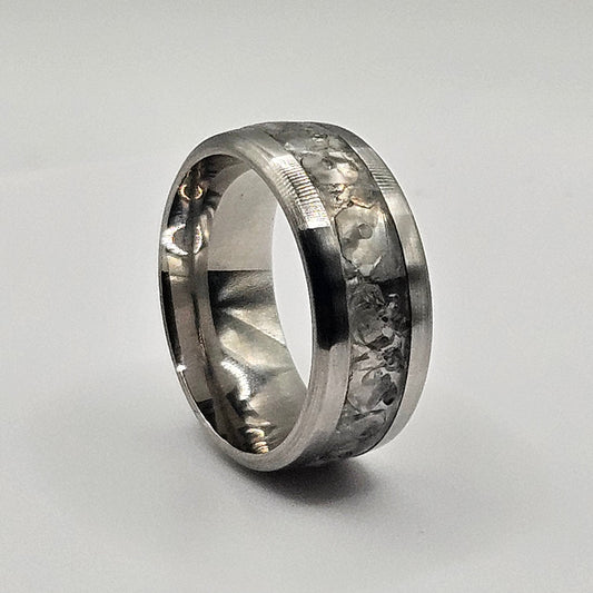 Silver ring with embedded stones on a light gray background