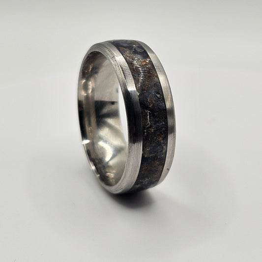 Silver ring with a dark blue inlay on a light gray background