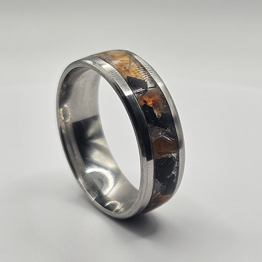 Silver ring with embedded material on a light gray background