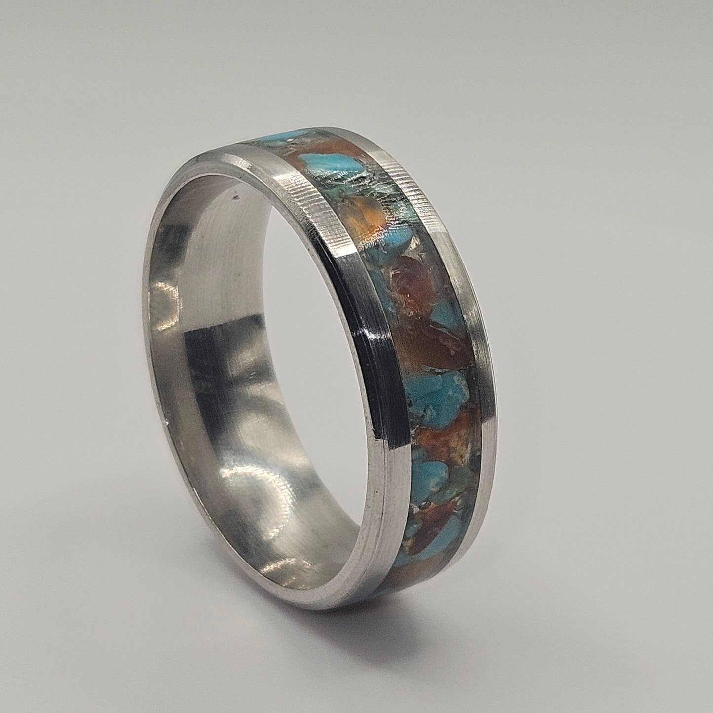 Silver ring with embedded stones on a gray background