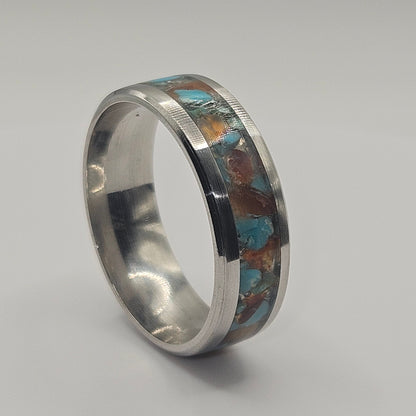 Silver ring with embedded stones on a gray background