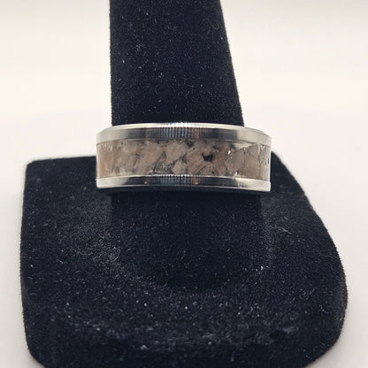 Silver ring on a black stand against a white background