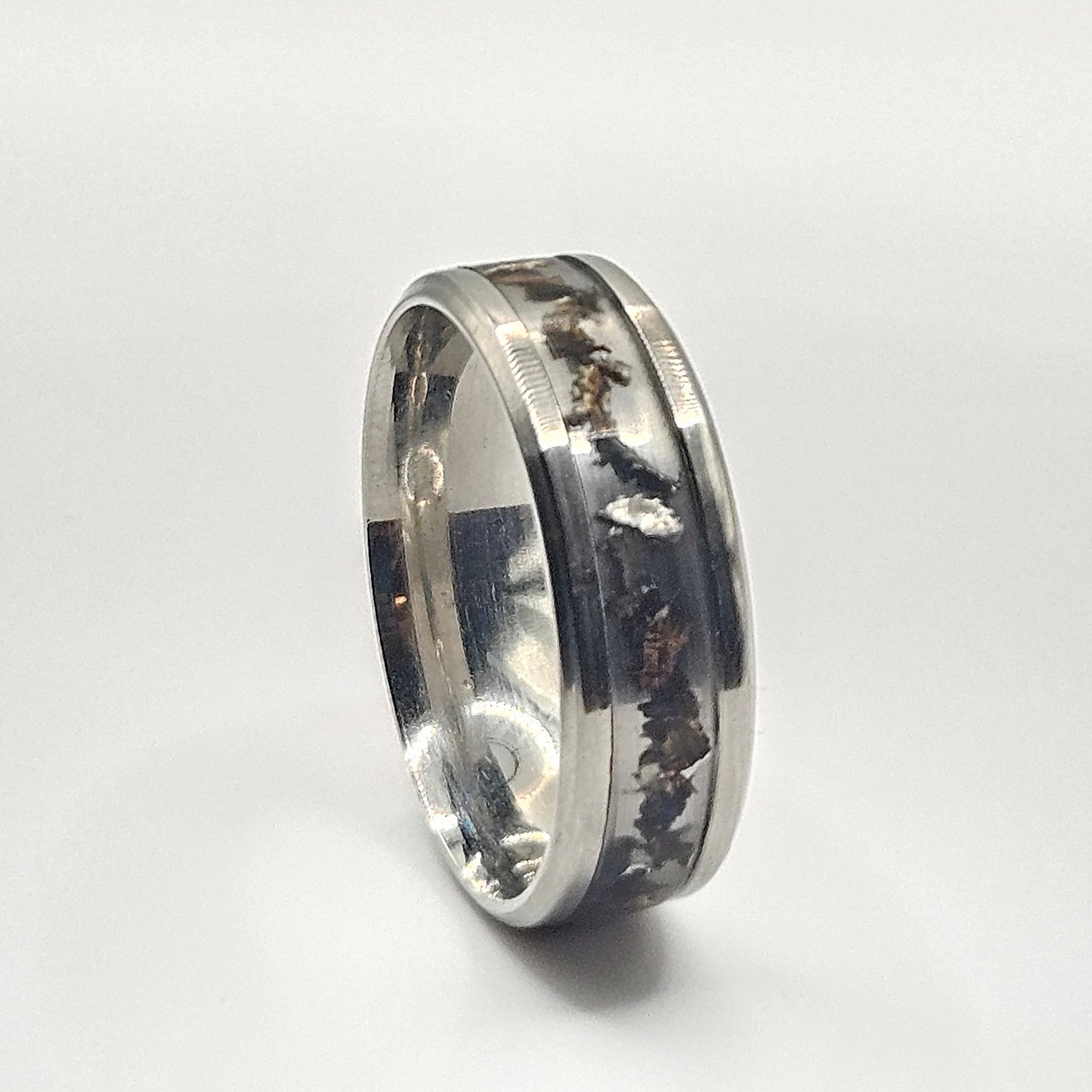 Silver ring with engraved design on a white background