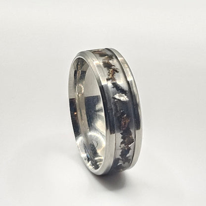 Silver ring with engraved design on a white background