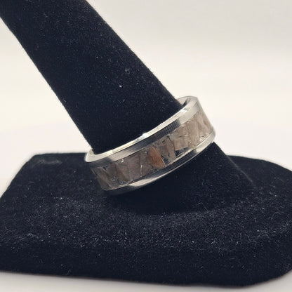 Silver ring on a black stand against a white background